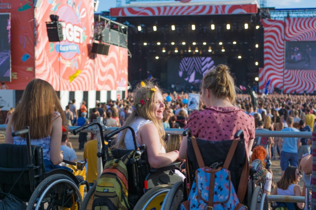 Zwei Rollstuhlfahrerinnen auf einem Festival.