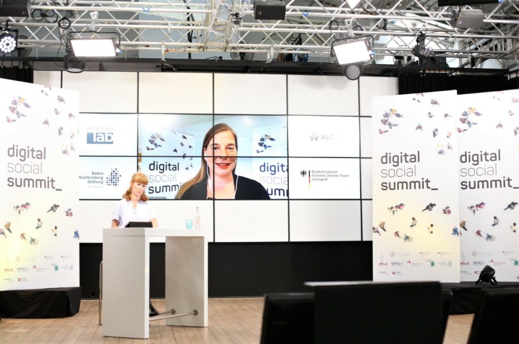 DSS-Moderatorin Teresa Sickert im Vordergrund, Katarina peranic im Hintergrund auf einem Bildschirm zu sehen.